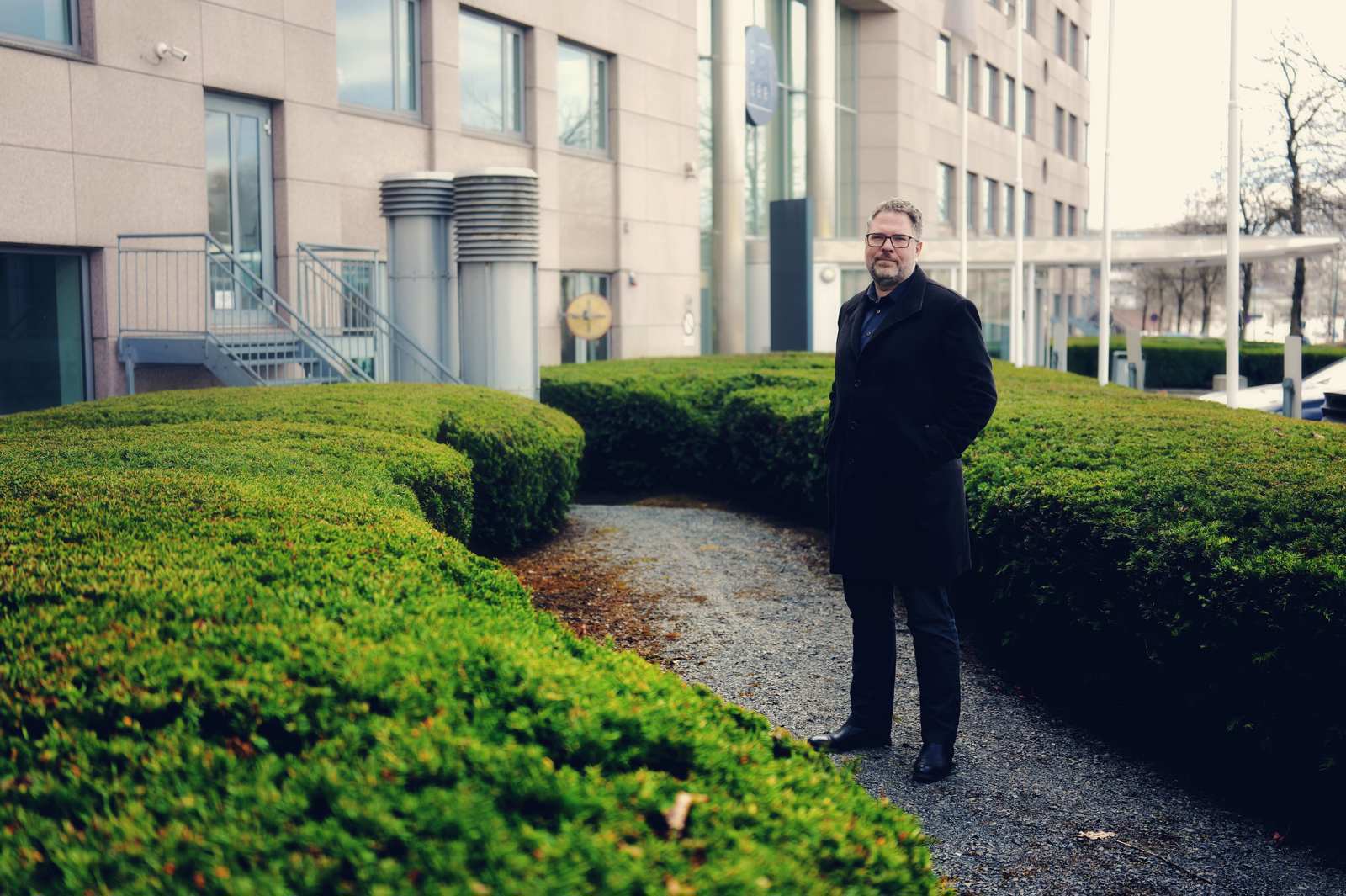 A man standing outside in the garden wearing black clothes 