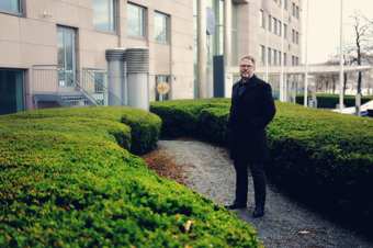 A man standing outside in the garden wearing black clothes 