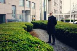 A man standing outside in the garden wearing black clothes 