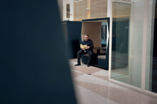 A man sitting at a table reading a book 