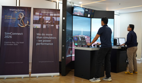 Two people using a maritime simulator with multiple navigation displays at a Kongsberg Maritime simulation setup.