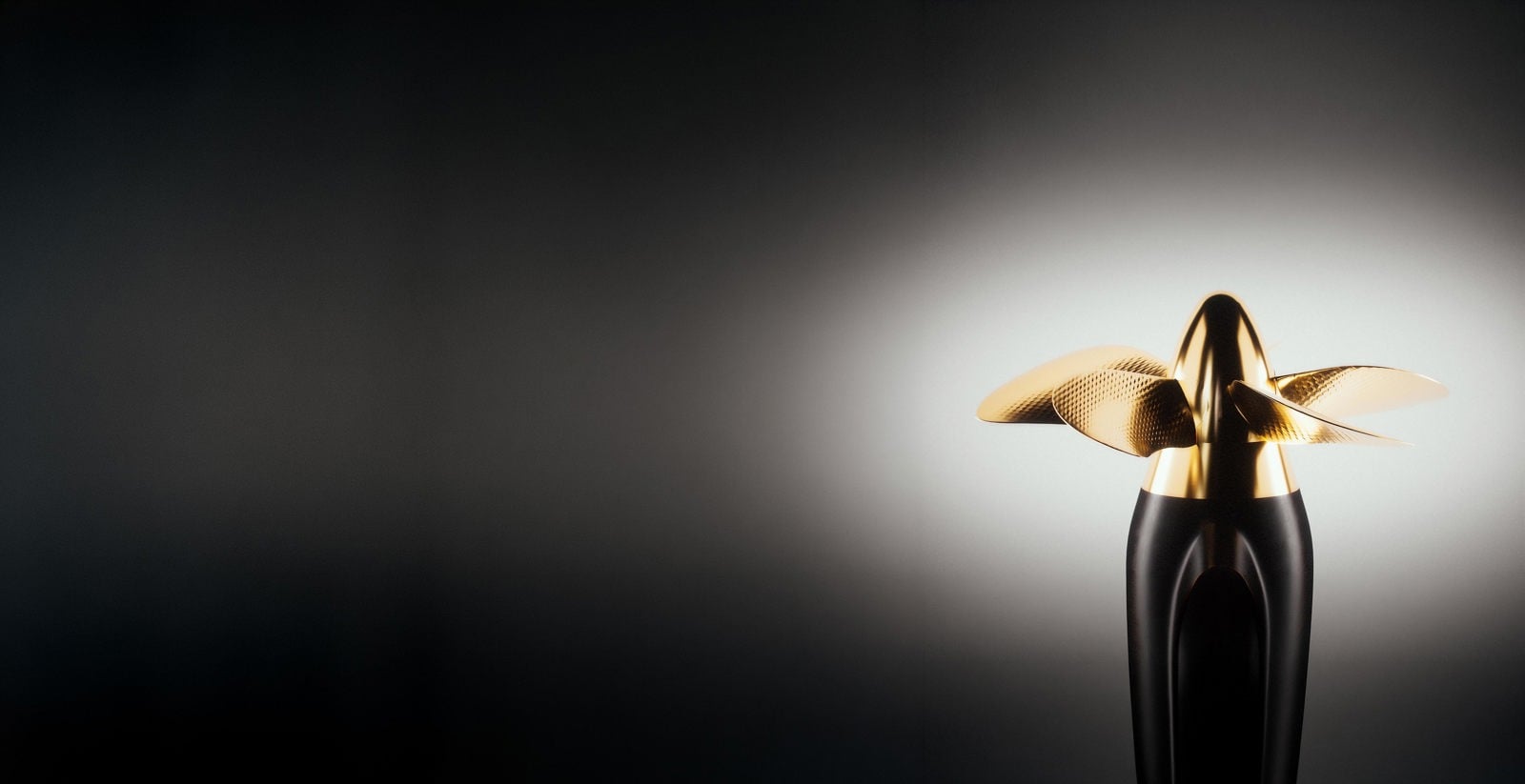 Stylized close-up of an Elegance Pod propeller and pod housing against a softly lit gradient background, emphasizing the hydrodynamic design and bronze finish.