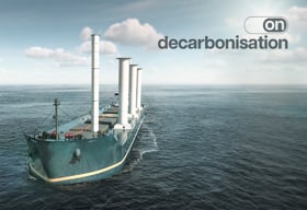 Cargo vessel equipped with wind-assisted propulsion sails across open water