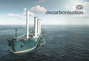 Cargo vessel equipped with wind-assisted propulsion sails across open water